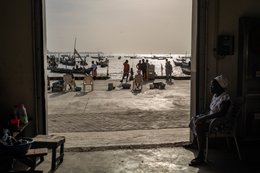 Accra;-Ghana;-Jamestown;-fishing-harbour;-fish-market;-fish-trader;-woman;-doorway;-interior;-exterior;-backlight;-composition;-new-harbour;-Sino-Ghanaian-cooperation;-artisanal-fishing;-daily-life;-Gulf-of-Guinea;-West-Africa;-documentary-photography;-Kaleidos;-Kaleidos-images;-La-parole-à-limage;-Stories-Pictures;-Tarek-Charara